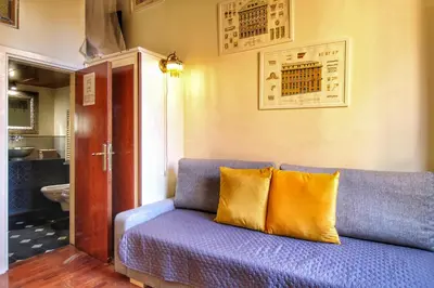 a blue couch with two yellow pillows in a room at Trastevere Charming Romantic Loft By YourHost in Rome