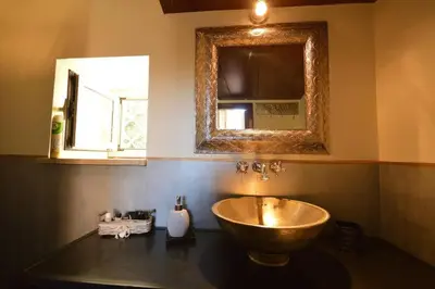 a bathroom with a copper sink and a mirror at Trastevere Charming Romantic Loft By YourHost in Rome