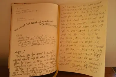 an open book with handwriting on the pages at Trastevere Charming Romantic Loft By YourHost in Rome