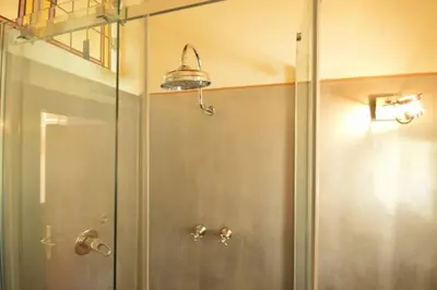 a shower with a glass door in a bathroom at Trastevere Charming Romantic Loft By YourHost in Rome