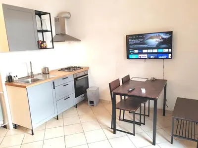 a kitchen with a table and a tv on the wall at Casa Aurelia in Rome