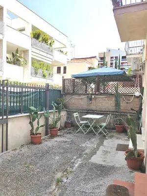 a patio with a table and umbrella and plants at Casa Aurelia in Rome
