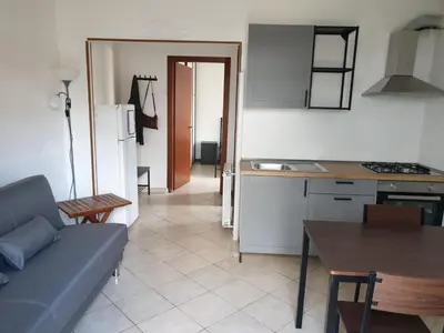 a kitchen and living room with a blue couch and a table at Casa Aurelia in Rome