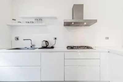 a kitchen with white cabinets and a sink at BBHOME Tiburtina Station apartment in Rome