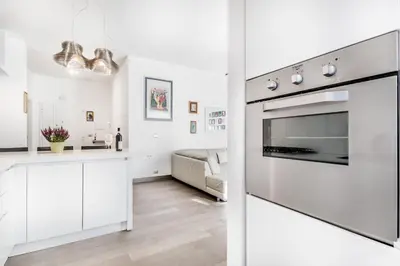 a kitchen and living room with a stainless steel oven at BBHOME Tiburtina Station apartment in Rome