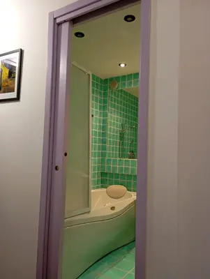 a bathroom with a tub and a shower with green tiles at GuestHost - Lovely Apartment ad un passo da Piazza del Popolo! in Rome