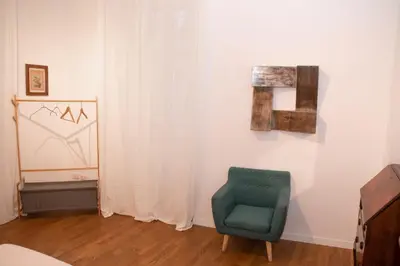 a room with a green chair and a curtain at pantheon luxury apartment in Rome