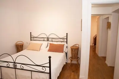 a bedroom with a bed with white sheets and orange pillows at pantheon luxury apartment in Rome