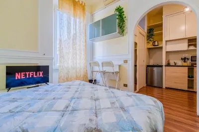 a large bedroom with a bed and a kitchen at Vatican Place in Rome