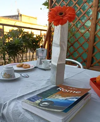 a flower in a vase sitting on top of a book at Casa Carbone in Rome