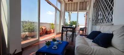 a living room with a white couch and a large window at appartamento panoramico su Roma in Rome