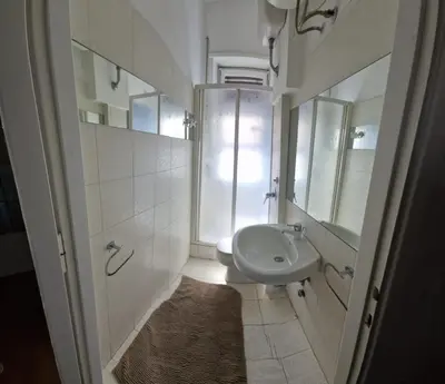 a white bathroom with a sink and a mirror at appartamento panoramico su Roma in Rome