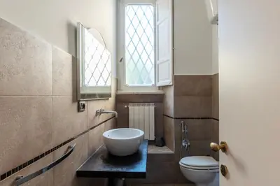 a bathroom with a sink and a toilet and a window at GuestHost - Tra Castel Sant'Angelo e Città del Vaticano Flat in Rome