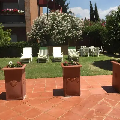 a group of chairs and tables and chairs in a yard at Nonna Cocchina House Rome close to Vatican City in Rome