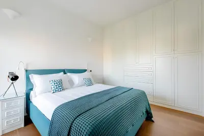 a bedroom with a blue and white bed and white cabinets at Nonna Cocchina House Rome close to Vatican City in Rome