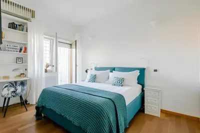 a bedroom with a blue and white bed and a book shelf at Nonna Cocchina House Rome close to Vatican City in Rome