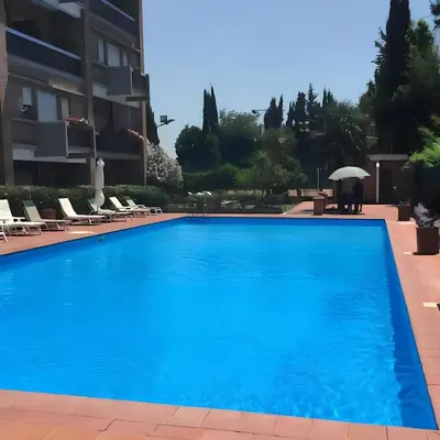 a large blue swimming pool in front of a building at Nonna Cocchina House Rome close to Vatican City in Rome