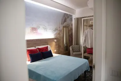 a bedroom with a bed with blue sheets and red pillows at Domus Coriolano in Rome
