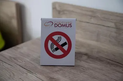 a no smoking donuts sign sitting on a table at Domus Coriolano in Rome