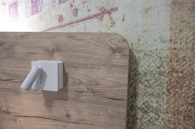 a white light switch on a wooden wall at Domus Coriolano in Rome
