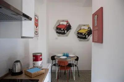 a kitchen with two pictures of cars on the wall at Domus Coriolano in Rome