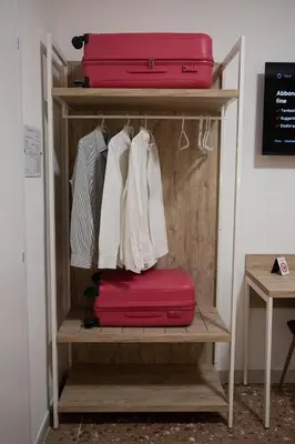 a shelf with two suitcases and a red suitcase at Domus Coriolano in Rome