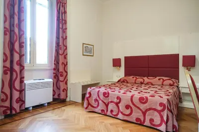 a bedroom with a bed with a red blanket and a window at Domus Lilium in Rome