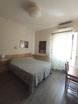 a bedroom with a bed and a large window at Casa Bambù in Rome