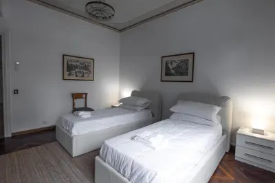 two beds in a room with white walls at The Majestic Residence in Vatican in Rome