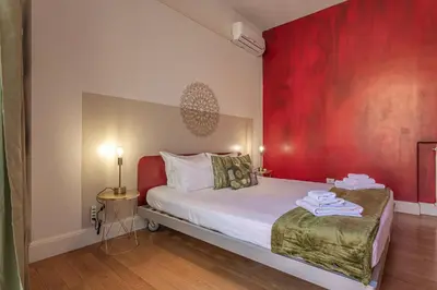 a bedroom with a red wall and a bed at Oasis Rome Centre Apartment in Rome