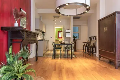 a living room with a table and chairs and a kitchen at Oasis Rome Centre Apartment in Rome