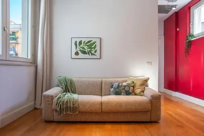 a living room with a couch and a red wall at Oasis Rome Centre Apartment in Rome