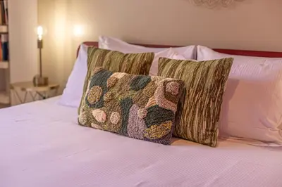 a bed with four pillows on top of it at Oasis Rome Centre Apartment in Rome