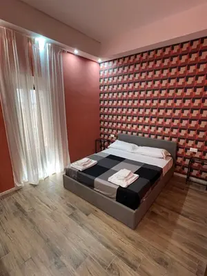a bedroom with a bed and a brick wall at Ele Suites Pantheon in Rome