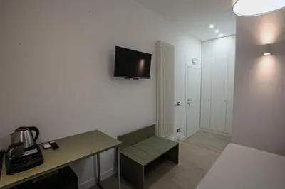 a room with a desk and a television on the wall at Colosseum Maison in Rome