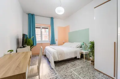 a bedroom with a bed and a table and a tv at Luigi's Home, Cozy Apartment Metro San Paolo in Rome