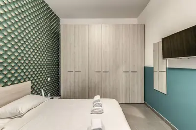 a bedroom with a white bed and a green wall at New Flat Near Termini Station in Rome
