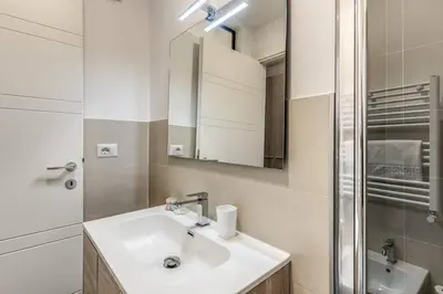 a white bathroom with a sink and a shower at New Flat Near Termini Station in Rome