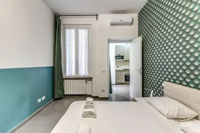 a bedroom with a white bed and a blue wall at New Flat Near Termini Station in Rome