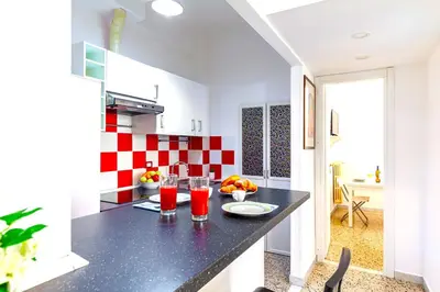 a kitchen with a black counter and red and white tiles at Hostly - Sant'Orsola Suite Apartment in Rome