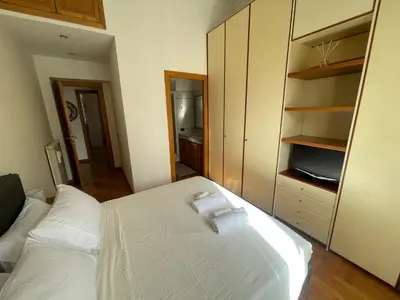 a bedroom with a white bed and a tv at A due passi da San Pietro in Rome