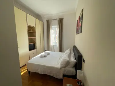 a bedroom with a bed with white sheets and pillows at A due passi da San Pietro in Rome
