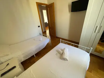 a room with two beds and a flat screen tv at A due passi da San Pietro in Rome