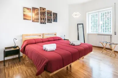 a bedroom with a large red bed with two towels at Cozy flat 2 bedrooms 2 bathrooms with balcony in Rome