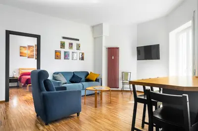 a living room with a blue couch and a table at Cozy flat 2 bedrooms 2 bathrooms with balcony in Rome