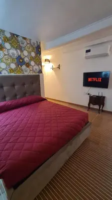 a bedroom with a bed with a red comforter at Hybris Campo De' Fiori in Rome