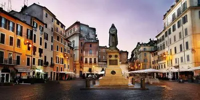 a statue in the middle of a city with buildings at Hybris Campo De' Fiori in Rome