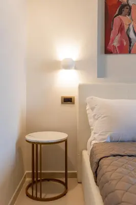 a small table next to a bed in a room at Dimora Cardinal Moroni in Rome