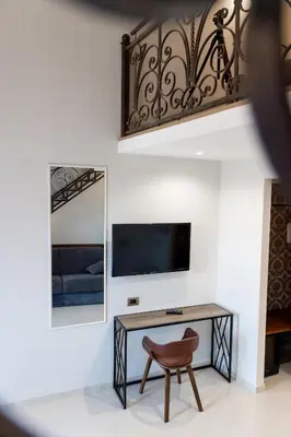 a room with a desk and a mirror and a chair at Dimora Cardinal Moroni in Rome