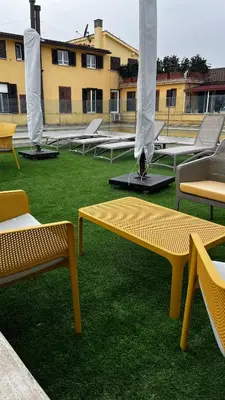 a group of benches sitting on the grass at Galileo Luxury Terrace Suites Rome in Rome